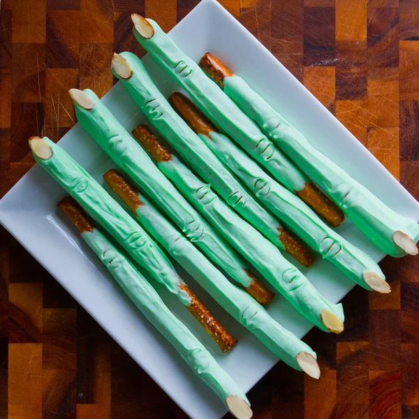 Doces de pretzel de Halloween verde assustador em um prato branco — Fotografia de Stock
