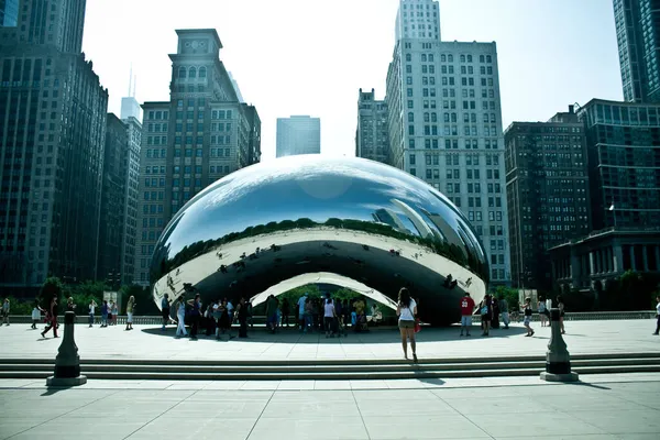 Chicagos O feijão centrado contra o horizonte de Chicago com turistas em torno da escultura — Fotografia de Stock