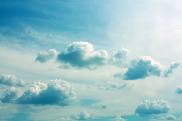 Fluffy and pillowy clouds drift along a blue and teal sky — Stock Photo, Image