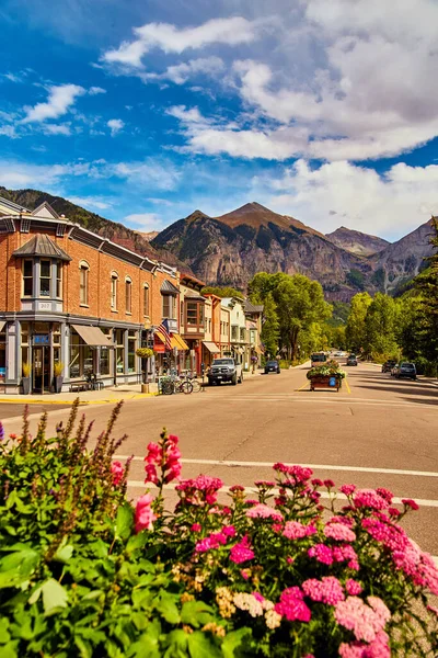 Pequena cidade nas montanhas com flores em primeiro plano — Fotografia de Stock