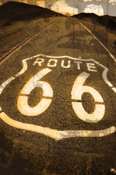 Straßenfarbe mit der Aufschrift Route 66 auf einer Straße, die sich bis zum Horizont erstreckt, mit sepiafarbenem Filter und gealtertem Look — Stockfoto