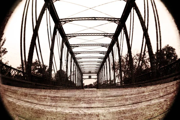 Fischaugenaufnahme aus der Wurmperspektive einer großen Stahlbrücke, die bis zum Horizont reicht — Stockfoto