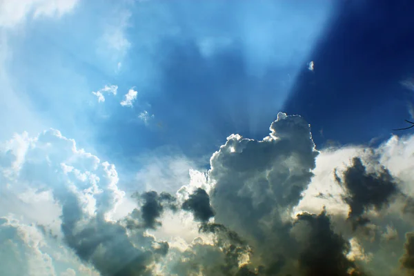 Heavenly light appears from white clouds on a blue sky — Stock Photo, Image