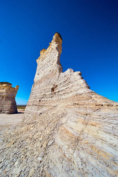 Close-up tegen de pilaar van witte rots in vlakke woestijn met levendige blauwe lucht — Stockfoto
