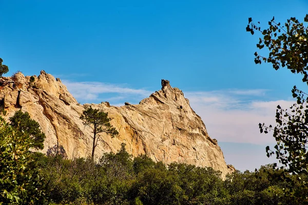 Paesaggio di cime rocciose contro alberi e cielo blu — Foto Stock