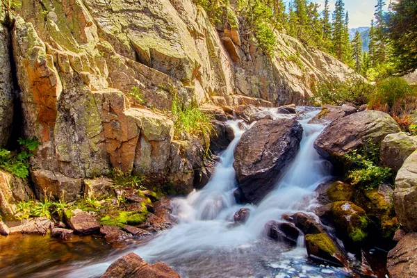 Cachoeira através de grandes rochas em montanhas com pedras de líquen — Fotografia de Stock