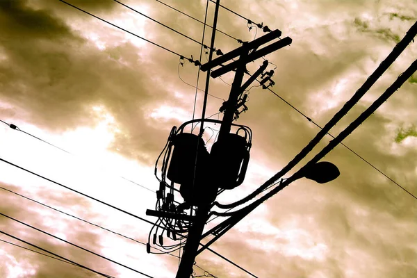 Telephone pole machinery against a yellowish orange cloudy sky — Stock Photo, Image