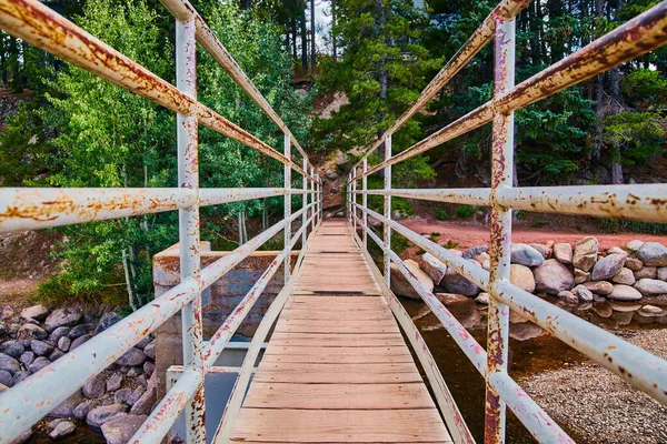 Pieni kävely silta yksityiskohta ruostunut kaide ja puu lankkuja joella — kuvapankkivalokuva