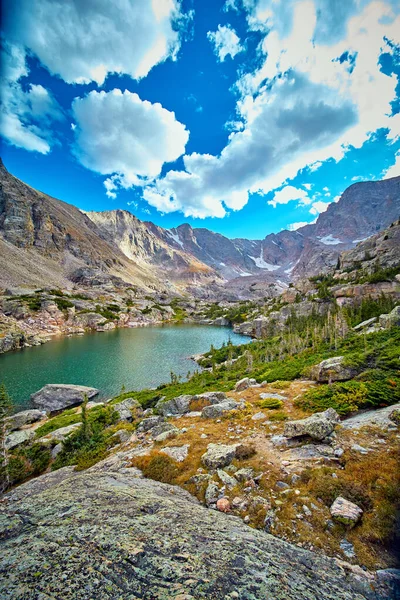 Lago en las montañas rocosas con roca de liquen en primer plano — Foto de Stock