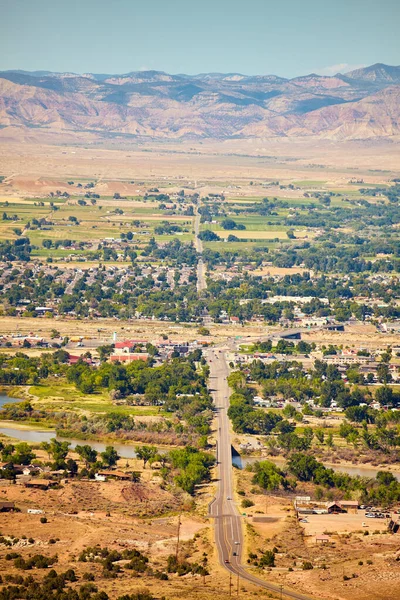 Woestijnvallei met kleine stad en bergen op de achtergrond — Stockfoto