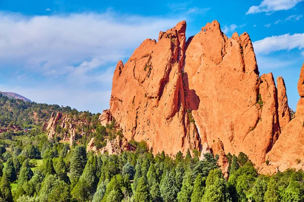 Ağaçların arasındaki büyük kızıl kaya dağı. — Stok fotoğraf