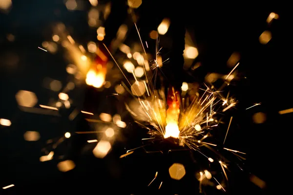金の炎と火花のシャワーを放つ一つの輝き — ストック写真