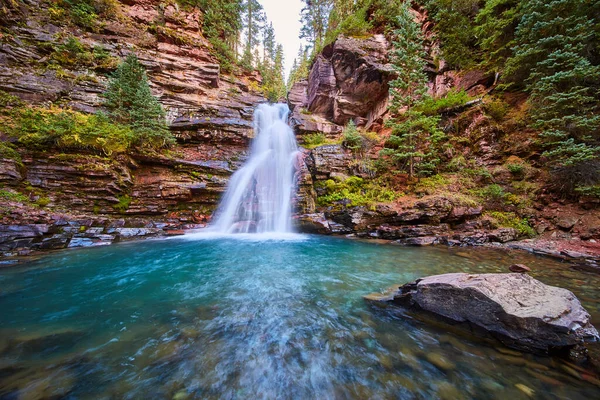 Rocha solitária no rio ao lado da bela cachoeira majestosa no desfiladeiro cercado por falésias — Fotografia de Stock