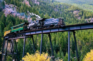 Dağlardaki köprüden geçen eski bir lokomotif treni.