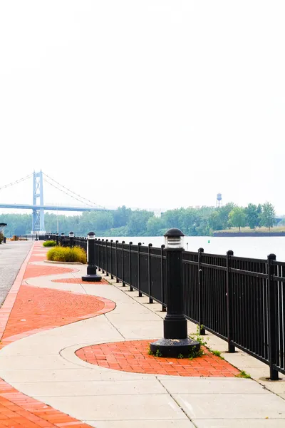 美国俄亥俄州托莱多市，一座带有锻铁栏杆的橙色和白色石桥在水面上穿行 — 图库照片