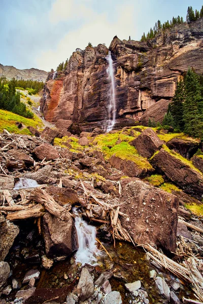 Gigantesca cascada sobre acantilados verticales que conducen a rocas de musgo en el valle —  Fotos de Stock