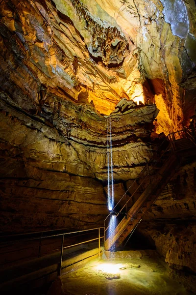 Wysoka kapiąca woda do dużej podziemnej jaskini ścieżką i schodami — Zdjęcie stockowe