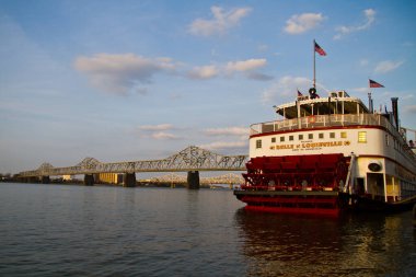 Büyük kırmızı beyaz feribot çelik bir köprünün altından geçiyor.