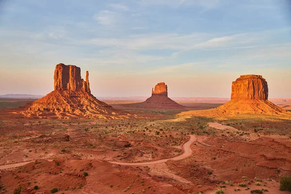 Arizona 'daki Anıt Vadisi' ndeki büyük kırmızı kaya sütunlarından geçen toprak yol. — Stok fotoğraf