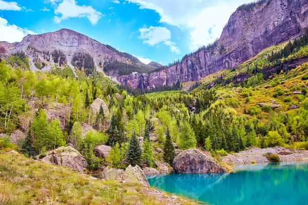 Pequeño lago escondido en el valle de la montaña cerca del otoño con cascada en el fondo — Foto de Stock