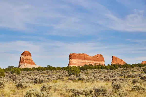 Red rock pillars in open landscape field of green — Stock Photo, Image