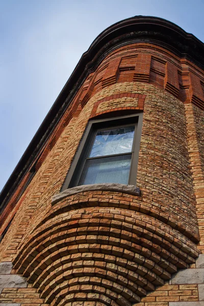 Edificio de ladrillo con una ventana redondeada sobresaliendo de una esquina — Foto de Stock