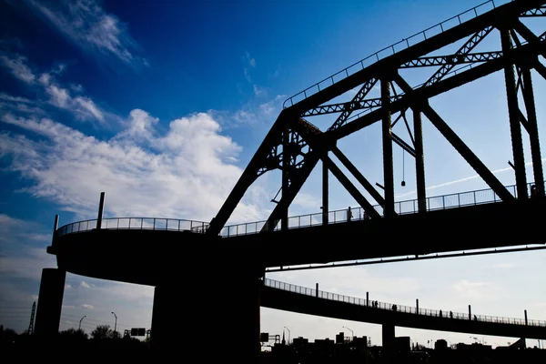 Silhueta de uma estrada e ponte de aço contra um céu azul — Fotografia de Stock