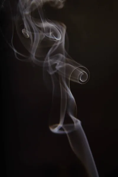 Curling humo blanco y gris sobre un fondo negro — Foto de Stock