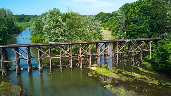 숲 속에서 분리 된 강을 횡단하는 오래 된 목조 철도 — 스톡 사진