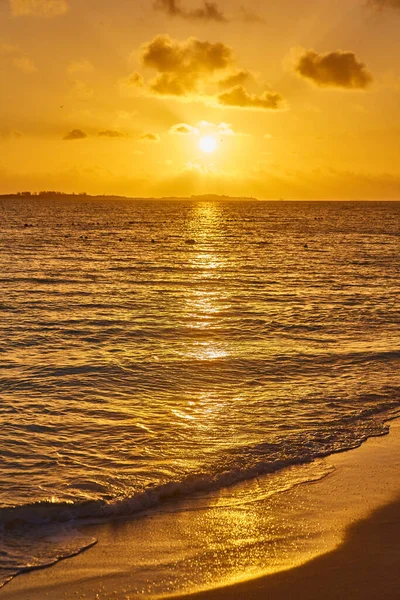 Wschód lub zachód słońca na plaży z falami wody i złotym blaskiem — Zdjęcie stockowe