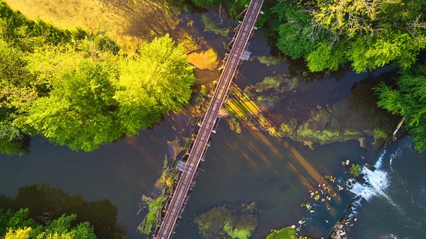 Puente de ferrocarril aéreo mirando hacia abajo cruzando el río con luz del atardecer — Foto de Stock
