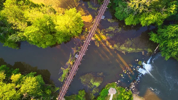 Vista aérea hacia abajo en el río y el bosque con cascadas artificiales de la presa y el puente de la vía del tren — Foto de Stock