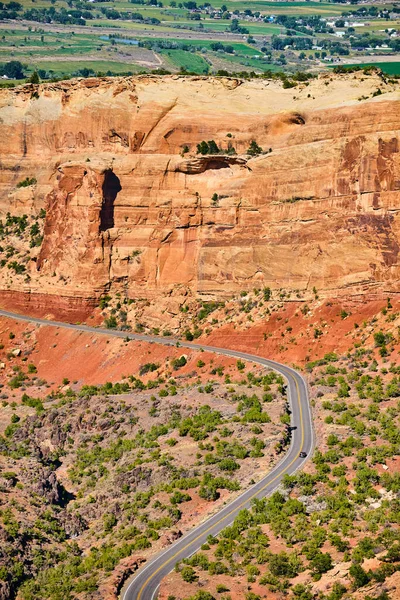 Scenic tourist road travelling through large desert canyon with red rock cliffs — Stock Photo, Image
