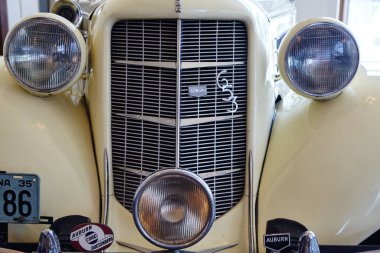 Uzun bir ızgarası ve gözleri gibi iki farlı antika beyaz bir arabanın ön fotoğrafını çek.