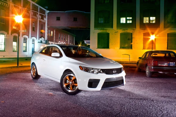 Bílé auto v městském prostředí s oranžovými světly — Stock fotografie
