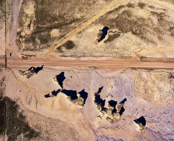 Vue aérienne d'en haut du désert avec route de terre et obélisque structures rocheuses avec voiture pour la perspective — Photo