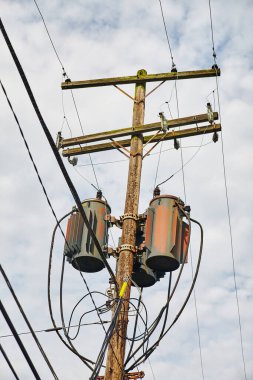 Bulutlu gökyüzüne karşı tahıl asansörlü eski ahşap telefon direği