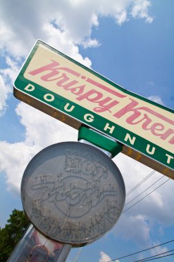 Eski bir Krispy Kreme işareti kısmen bulutlu bir gökyüzüne karşı