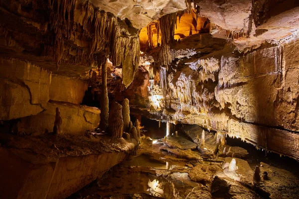 Duży otwór jaskiniowy z formacjami skalnymi i odbijającymi stalagmity wodne i stalaktyty — Zdjęcie stockowe