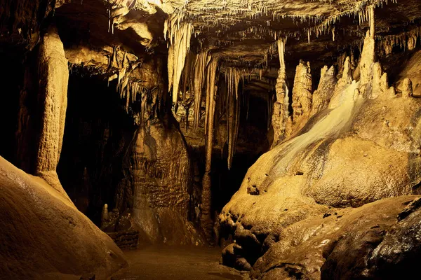 Żółty blask wokół formacji skalnych jaskiń stalagmity i stalaktyty — Zdjęcie stockowe