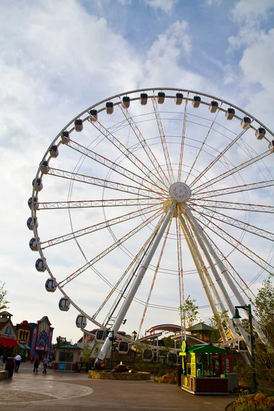 Large ferris wheel in the middle of a fair set against a partly cloudy sky — Stock Photo, Image