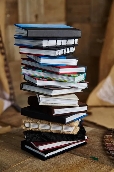 Stapelweise kleine bunte handgefertigte Bücher auf einer Holzoberfläche — Stockfoto