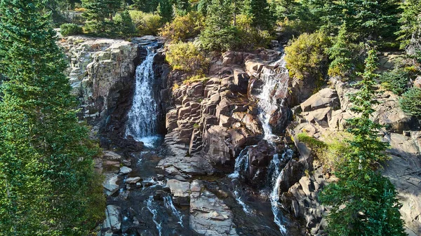 Vista de cascatas gêmeas divididas contra rochas em camadas — Fotografia de Stock