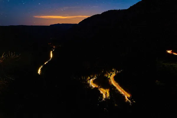Tmavá noc západ slunce horské silnice s reflektory aut — Stock fotografie