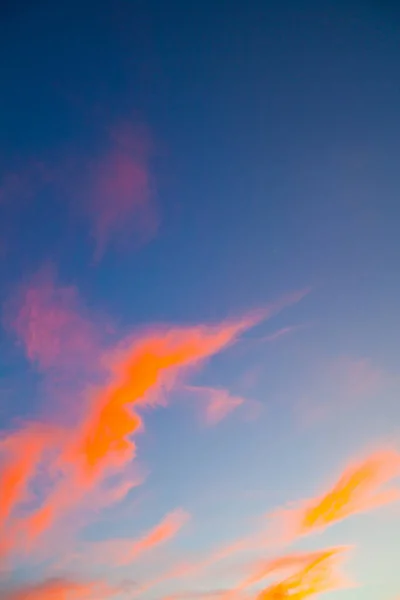 Neón naranja delgadas nubes tenues en un cielo azul —  Fotos de Stock