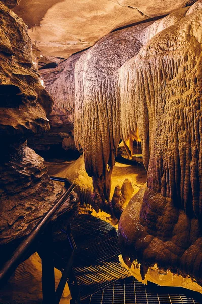 Металева доріжка через підземну печеру тур зі сталагмітами та стеблами — стокове фото