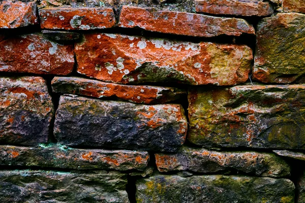 Szczegóły tekstury kolorowych kamiennych ścian z czerwonym i porostów — Zdjęcie stockowe