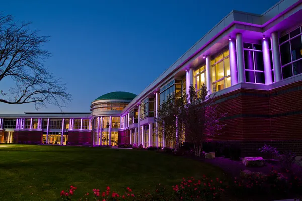 有许多窗户的现代建筑在暮色中点亮了紫色的灯 — 图库照片