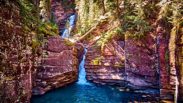 Глубокое ущелье покрытых лишайником красных скал со слоями водопадов — стоковое фото