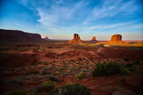 Monument Vadisi 'nde toprak yolu olan geniş bir çöl manzarası. Büyük kırmızı kayalar ve mavi gökyüzü. — Stok fotoğraf